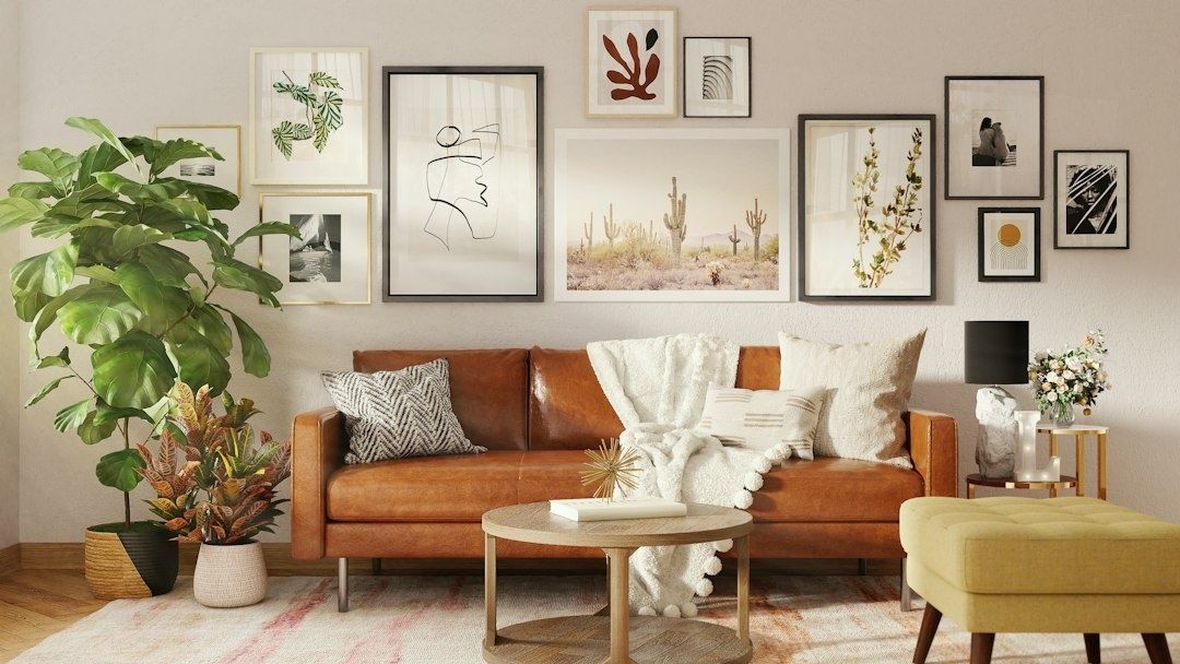 Woonkamer met kunstwerken aan de muur boven een leren bank